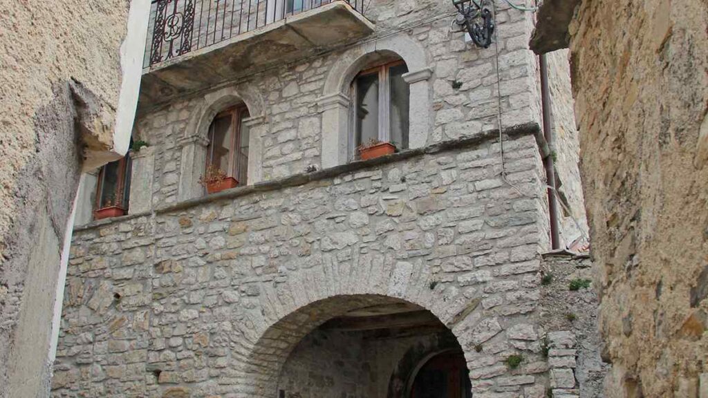 Facciata in pietra del Palazzo Baronale di Castelpizzuto con balcone in ferro battuto, finestre ad arco e portale d'ingresso