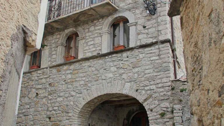 Facciata in pietra del Palazzo Baronale di Castelpizzuto con balcone in ferro battuto, finestre ad arco e portale d'ingresso