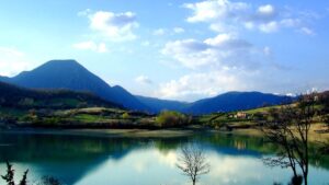Il lago artificiale color turchese di Castel San Vincenzo, con le Mainarde sullo sfondo